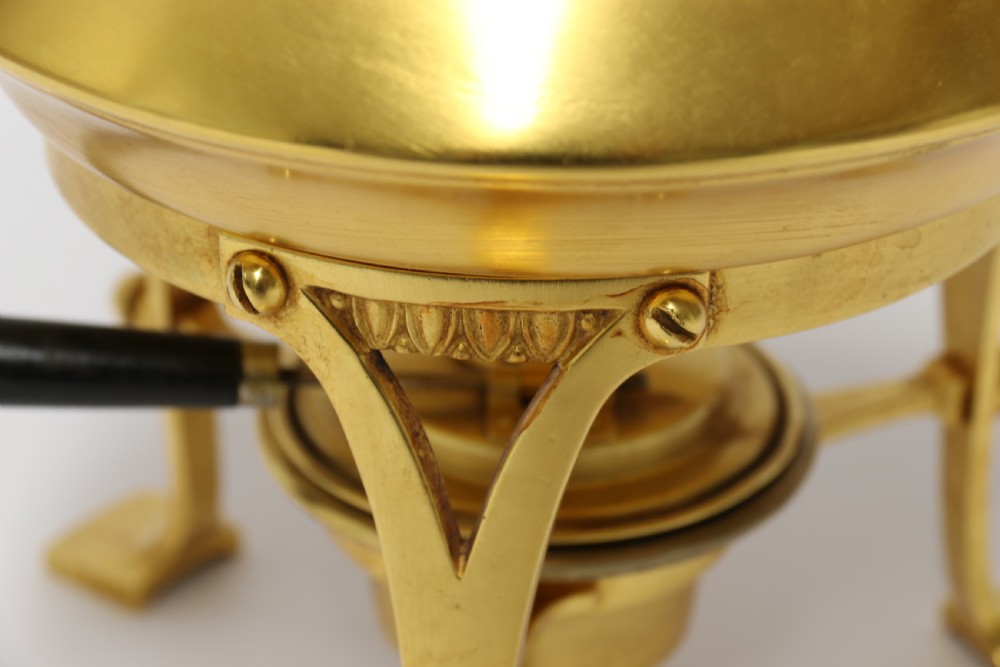 A late 19th-century Aesthetic Movement brass spirit kettle with a cane-wrapped handle, resting on a tripod brass stand with an alcohol burner. View V