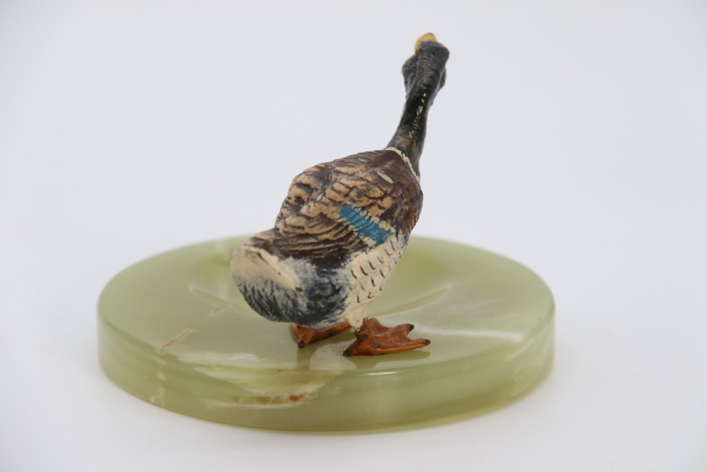 A cold painted bronze study of a mallard duck standing on the rim of a dished, circular green onyx base. View VII