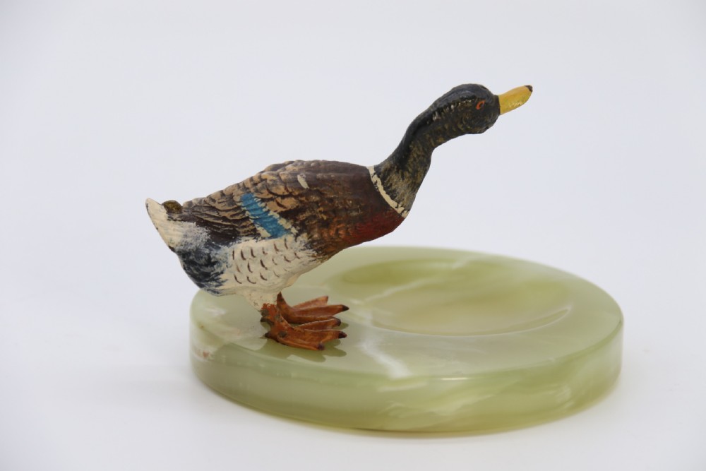 A cold painted bronze study of a mallard duck standing on the rim of a dished, circular green onyx base. View VIII