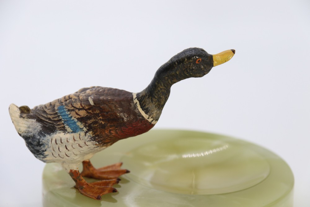 A cold painted bronze study of a mallard duck standing on the rim of a dished, circular green onyx base. View XII