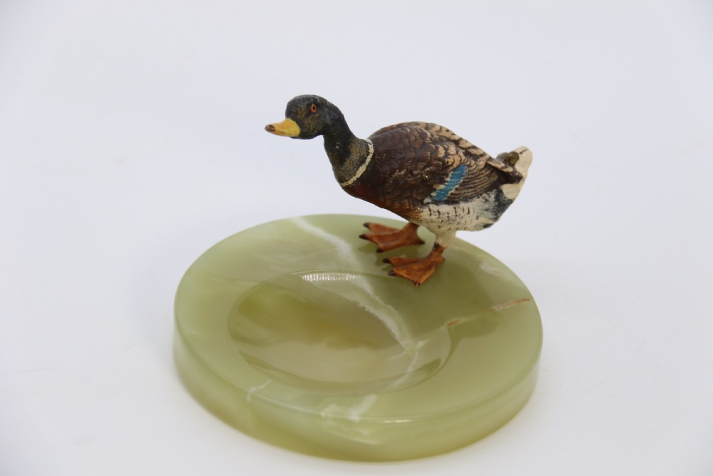 A cold painted bronze study of a mallard duck standing on the rim of a dished, circular green onyx base. View XIII