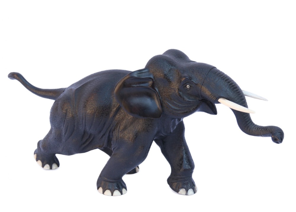 A late 19th-century hand-carved black ebony elephant sculpture shown in a striding pose with inlaid bone tusks and toenails. View II