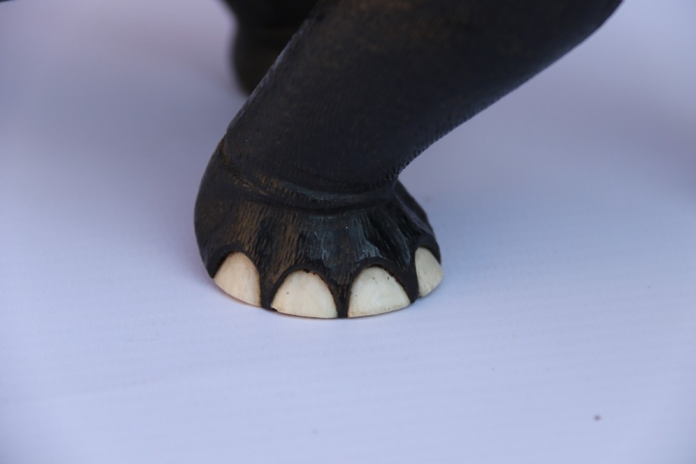 A late 19th-century hand-carved black ebony elephant sculpture shown in a striding pose with inlaid bone tusks and toenails. View XV