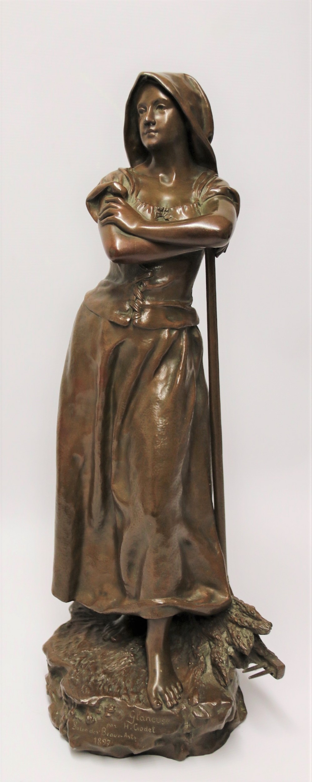 A 19th century  French bronze sculpture of a young female gathering hey at harvest