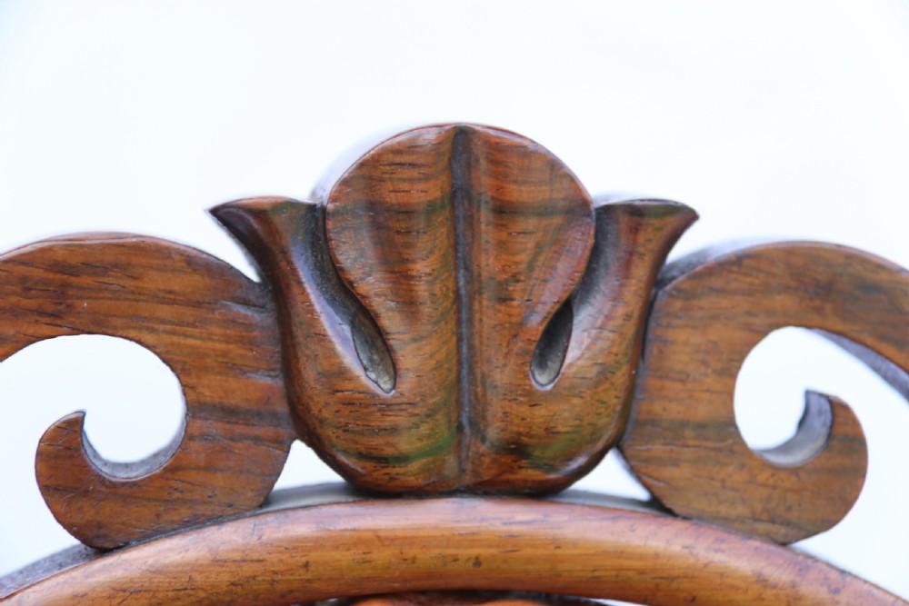 An early Victorian childs chair crafted from carved rosewood with barley twist columns, turned legs, and button-tufted brown leather upholstery on the seat and backrest. View XIV
