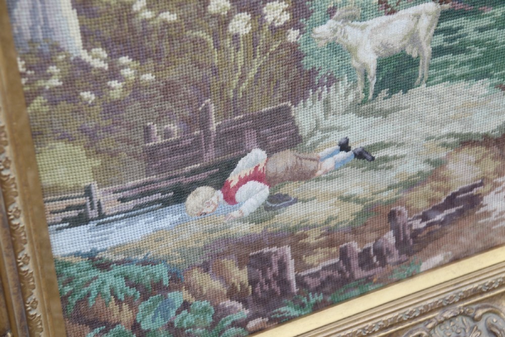 A large framed woolwork needlepoint tapestry depicting a pastoral landscape scene enclosed in a heavily ornamented giltwood frame. View XII