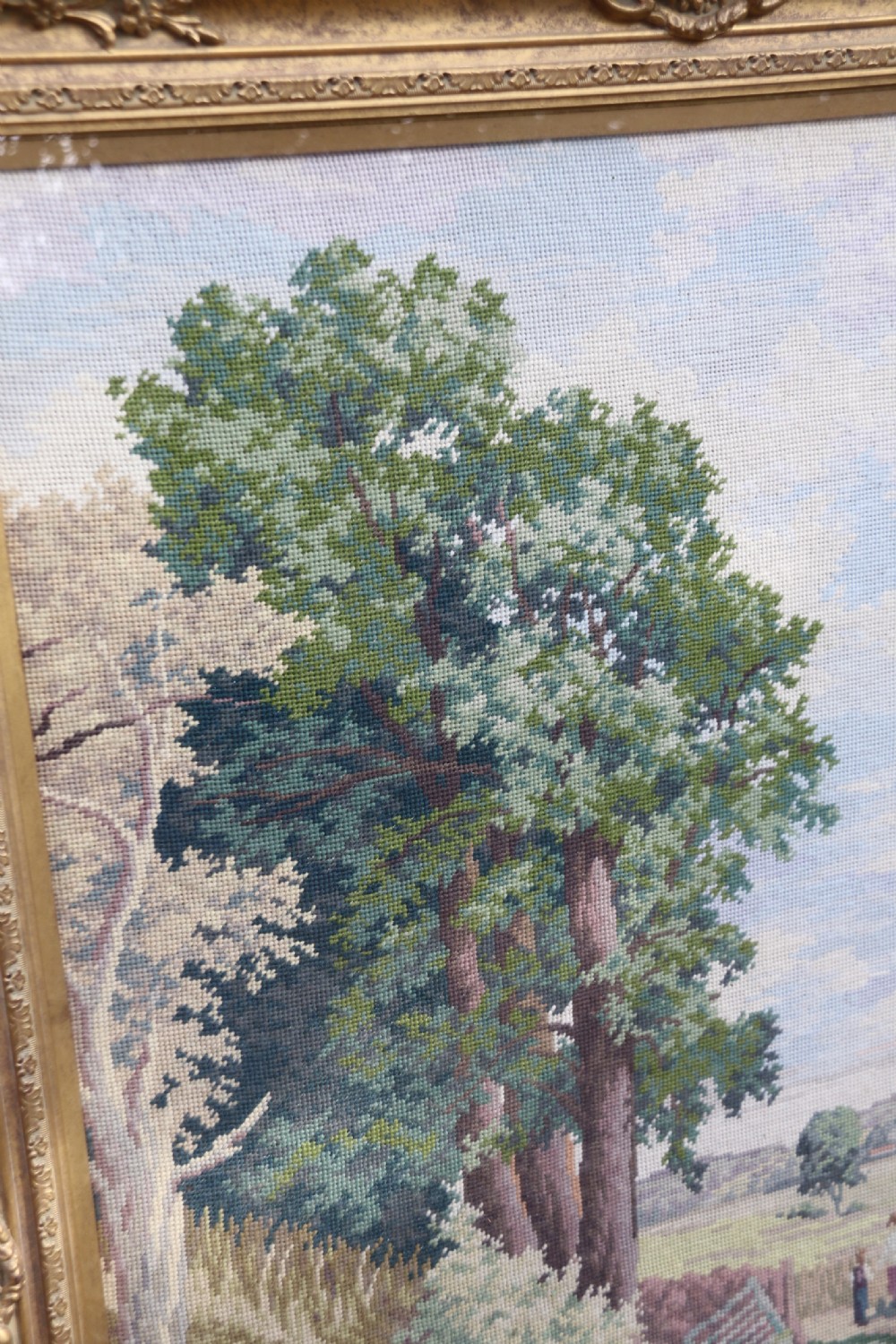 A large framed woolwork needlepoint tapestry depicting a pastoral landscape scene enclosed in a heavily ornamented giltwood frame. View XIV