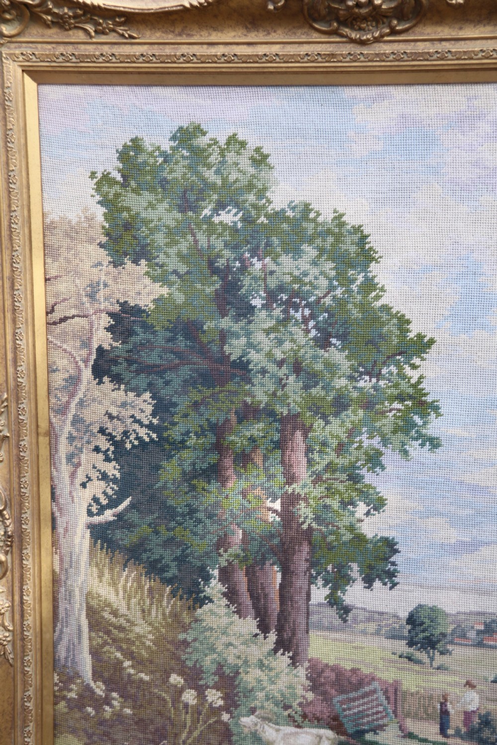 A large framed woolwork needlepoint tapestry depicting a pastoral landscape scene enclosed in a heavily ornamented giltwood frame. View XVIII