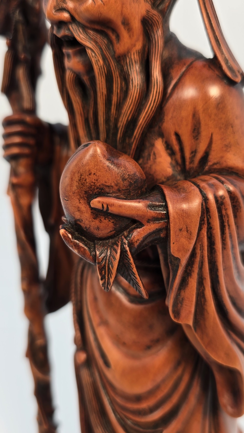 A Japanese carved boxwood okimono figure depicting Fukurokuju with a high forehead, long beard, flowing robes, and holding a gnarled staff. View XIII