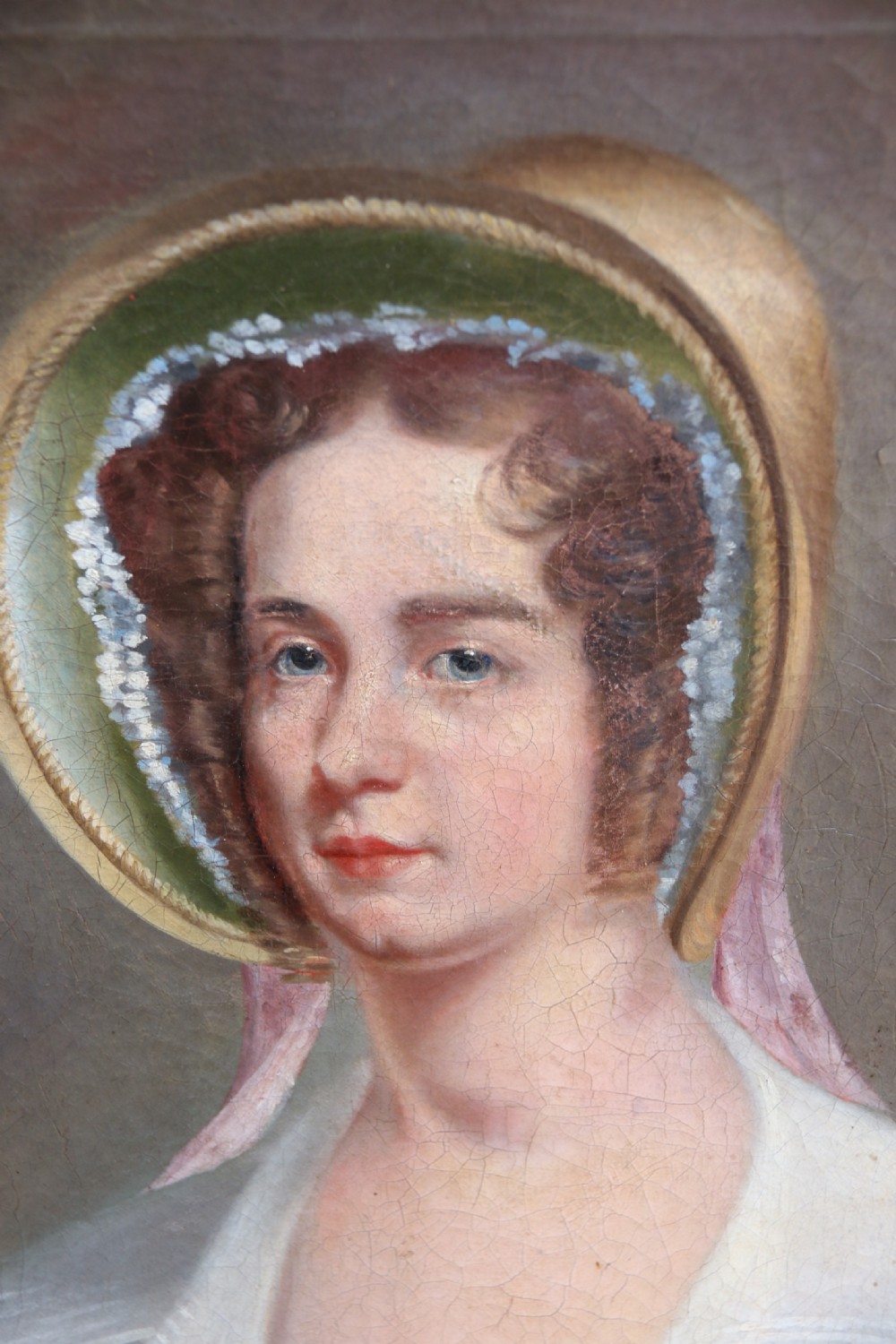 An early 19th-century oil painting on canvas depicting a woman in a bonnet and lace collar, housed within a wide oak frame with a gold inner slip. View II