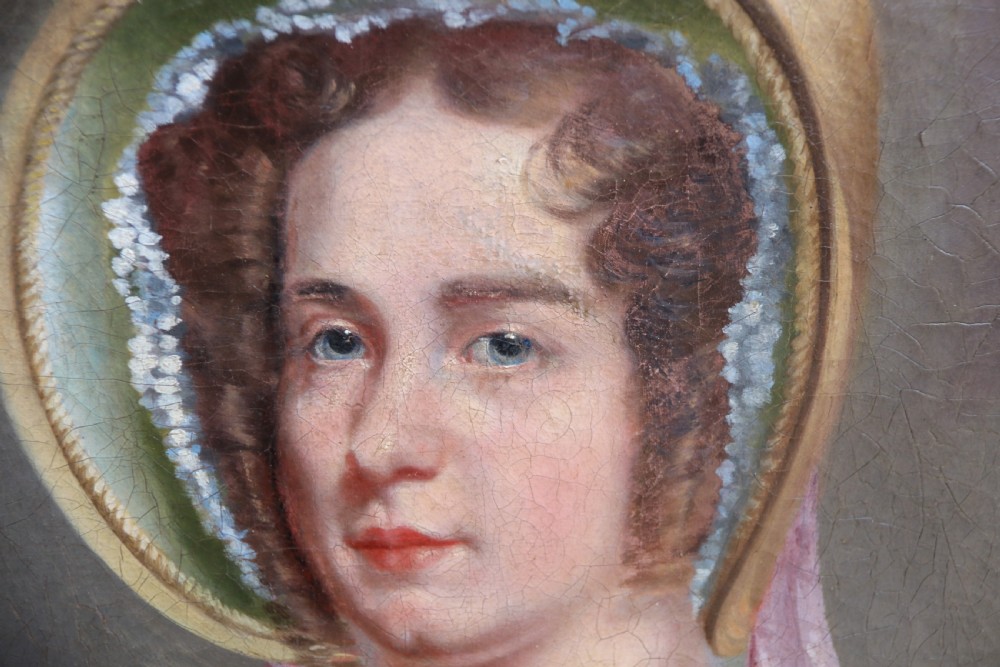 An early 19th-century oil painting on canvas depicting a woman in a bonnet and lace collar, housed within a wide oak frame with a gold inner slip. View IV