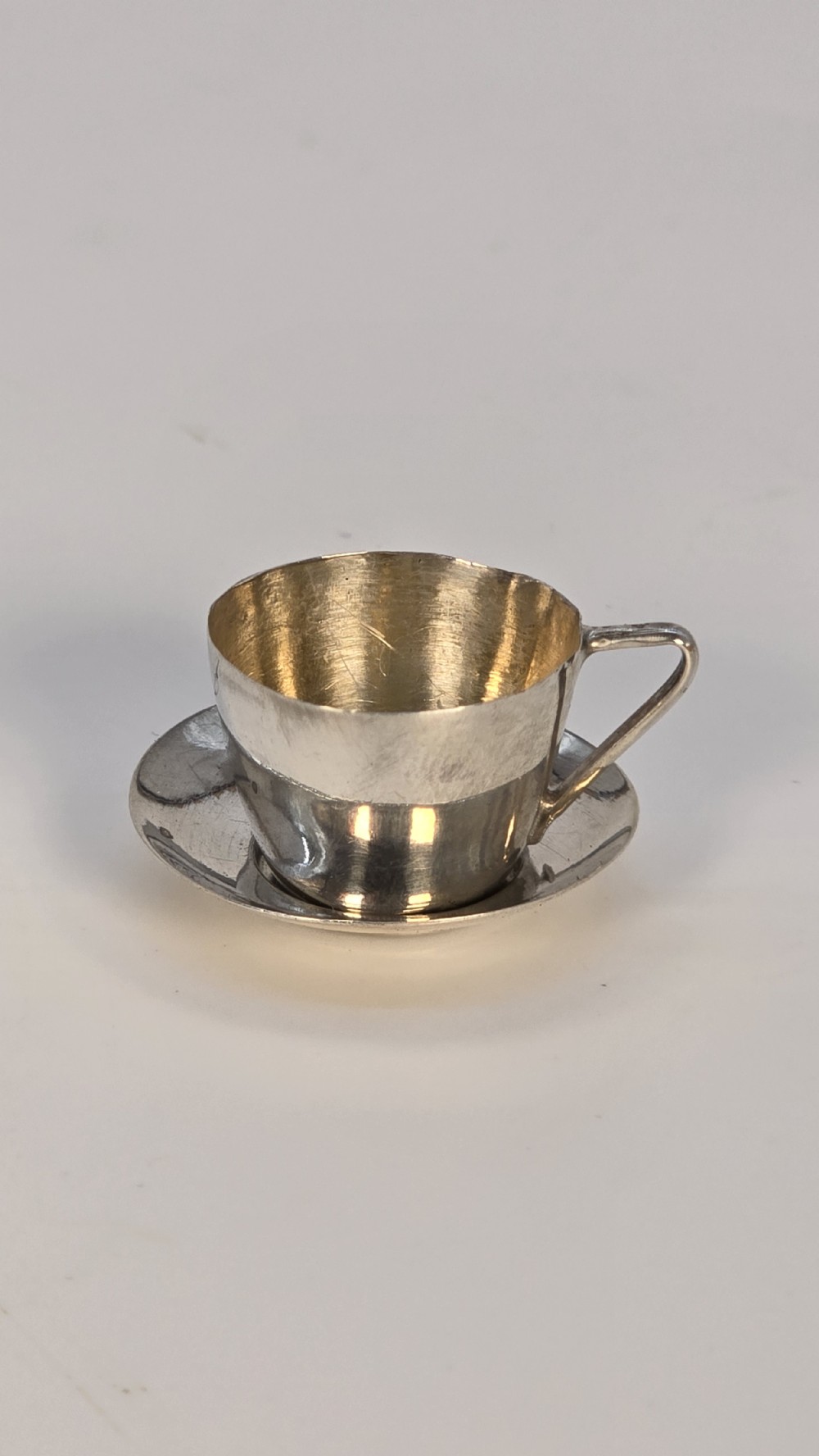 An Edwardian solid silver miniature chocolate set including a tapered pot with a wooden handle, cream jug, sugar bowl, and two cups with saucers. View XVIII