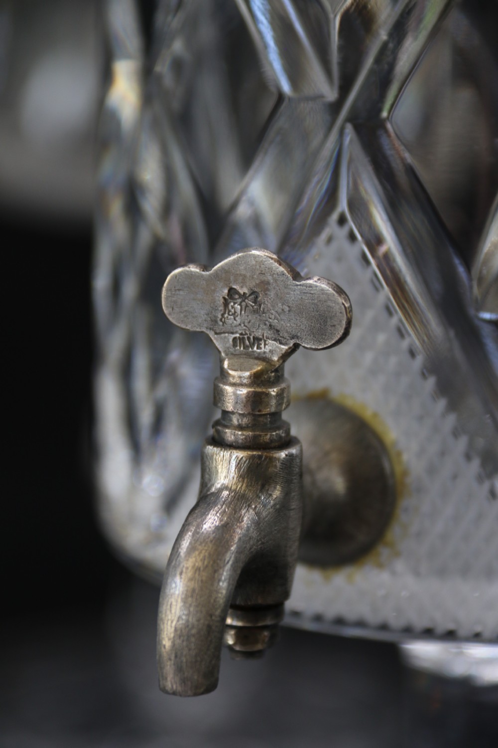 A set of five cut crystal perfume display bottles with faceted stoppers, diamond cut bodies, and silver spigots. View VI