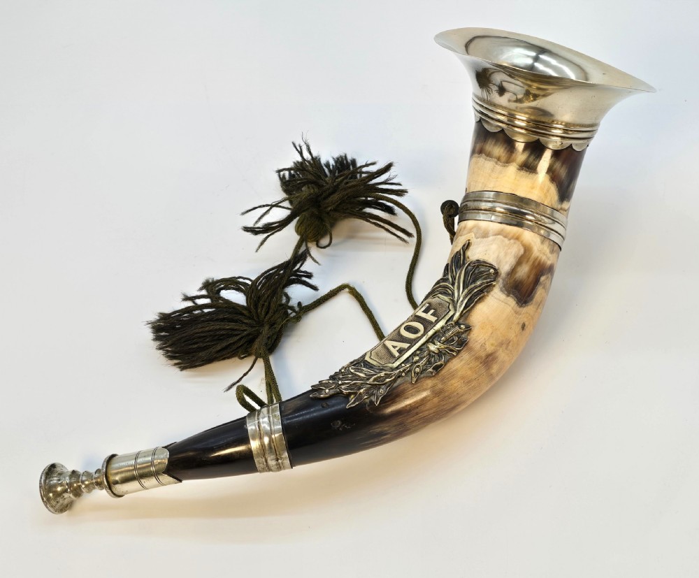 A Victorian natural horn featuring silver-plated mounts, an engraved foliage crest with the letters AOF, and dark braided tassels. View VI