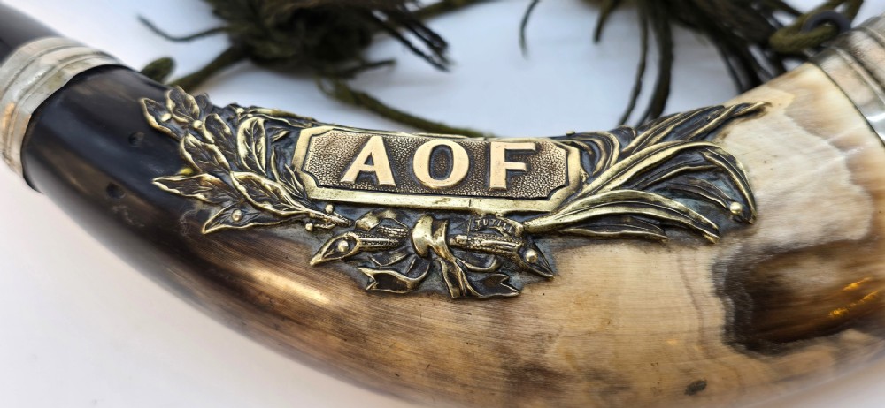A Victorian natural horn featuring silver-plated mounts, an engraved foliage crest with the letters AOF, and dark braided tassels. View X