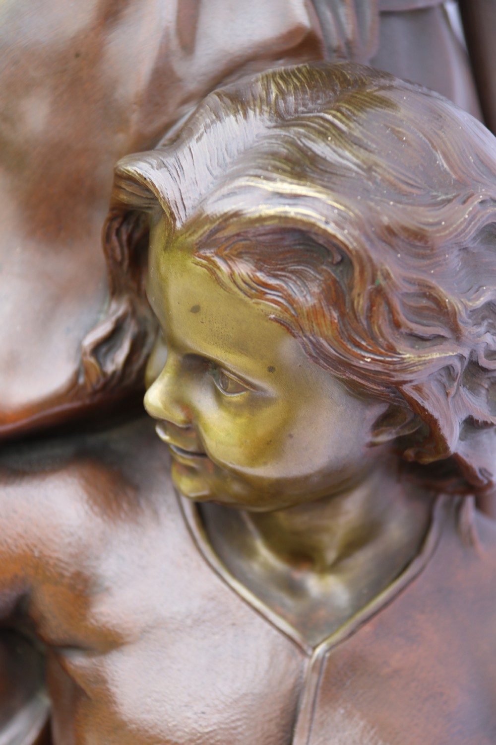 A late nineteenth-century patinated bronze sculpture depicting a woman holding a spinning distaff beside a young child clinging to her skirt. View XI