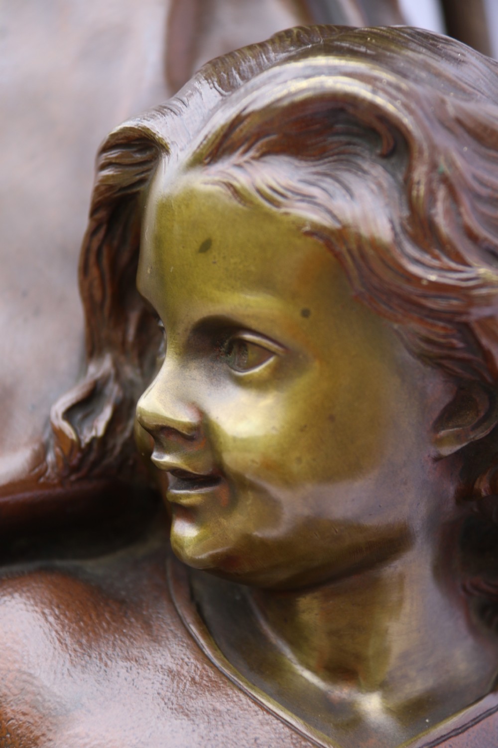 A late nineteenth-century patinated bronze sculpture depicting a woman holding a spinning distaff beside a young child clinging to her skirt. View XII