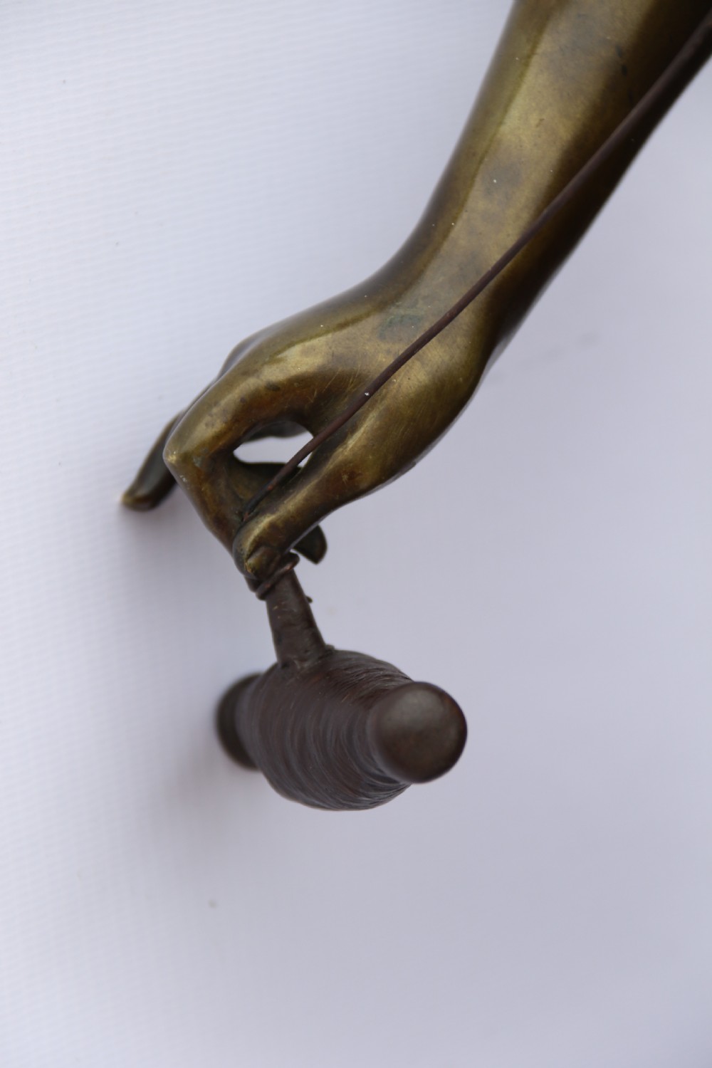 A late nineteenth-century patinated bronze sculpture depicting a woman holding a spinning distaff beside a young child clinging to her skirt. View XXIII