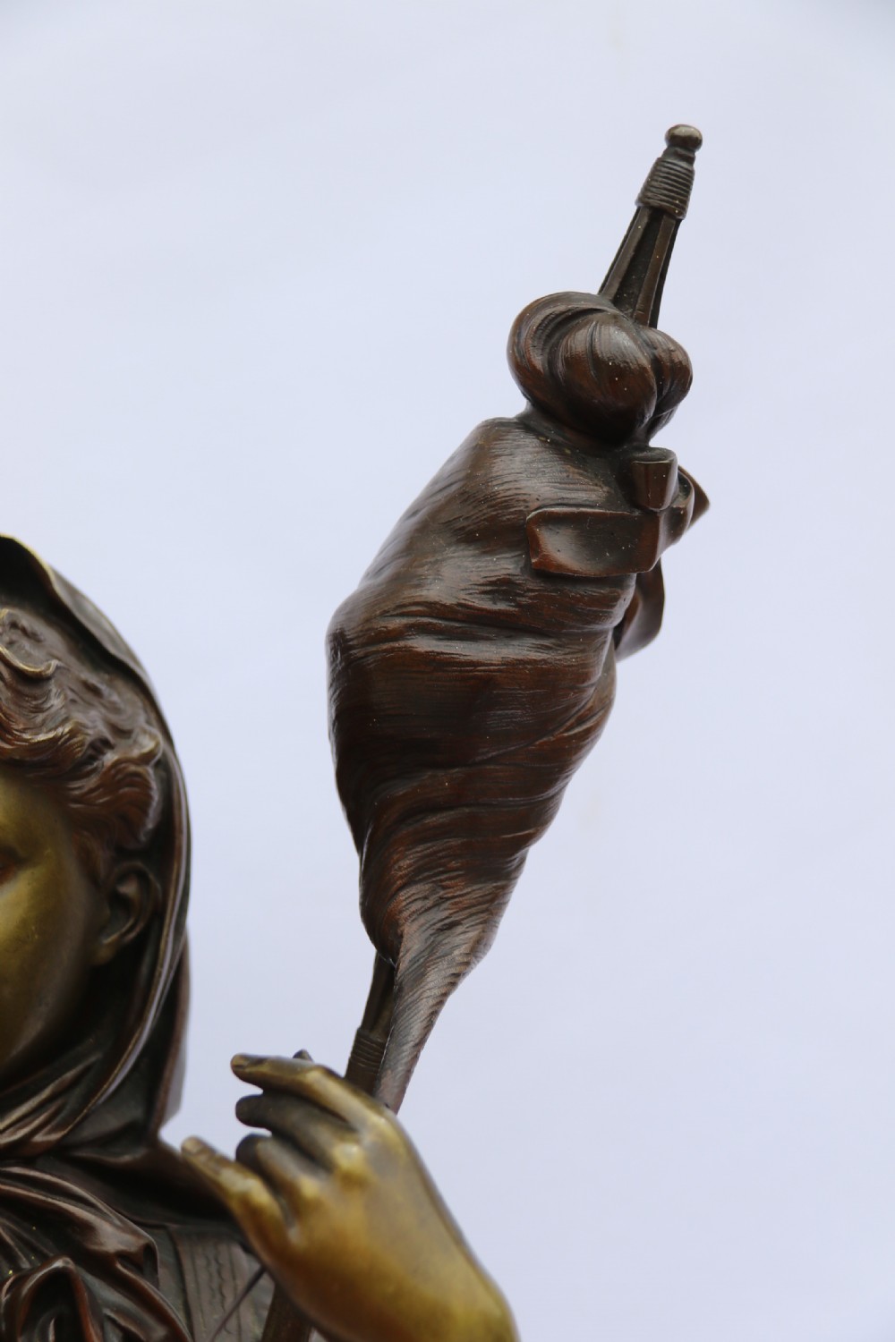A late nineteenth-century patinated bronze sculpture depicting a woman holding a spinning distaff beside a young child clinging to her skirt. View XXVIII