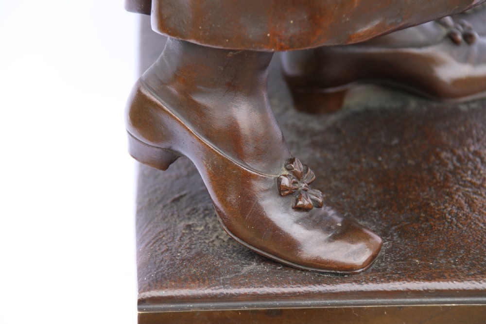 A late nineteenth-century patinated bronze sculpture depicting a woman holding a spinning distaff beside a young child clinging to her skirt. View XXIX