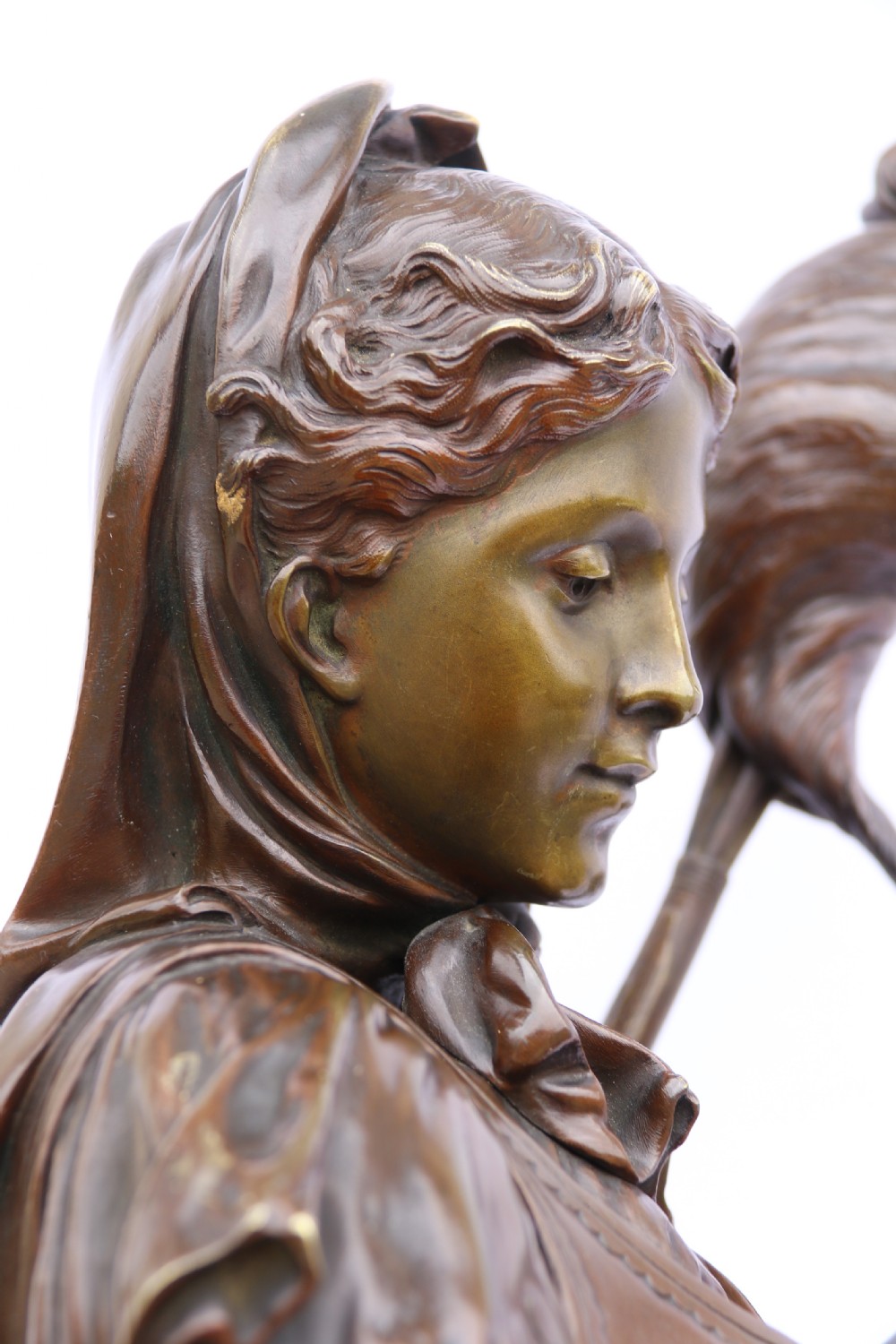 A late nineteenth-century patinated bronze sculpture depicting a woman holding a spinning distaff beside a young child clinging to her skirt. View XXX
