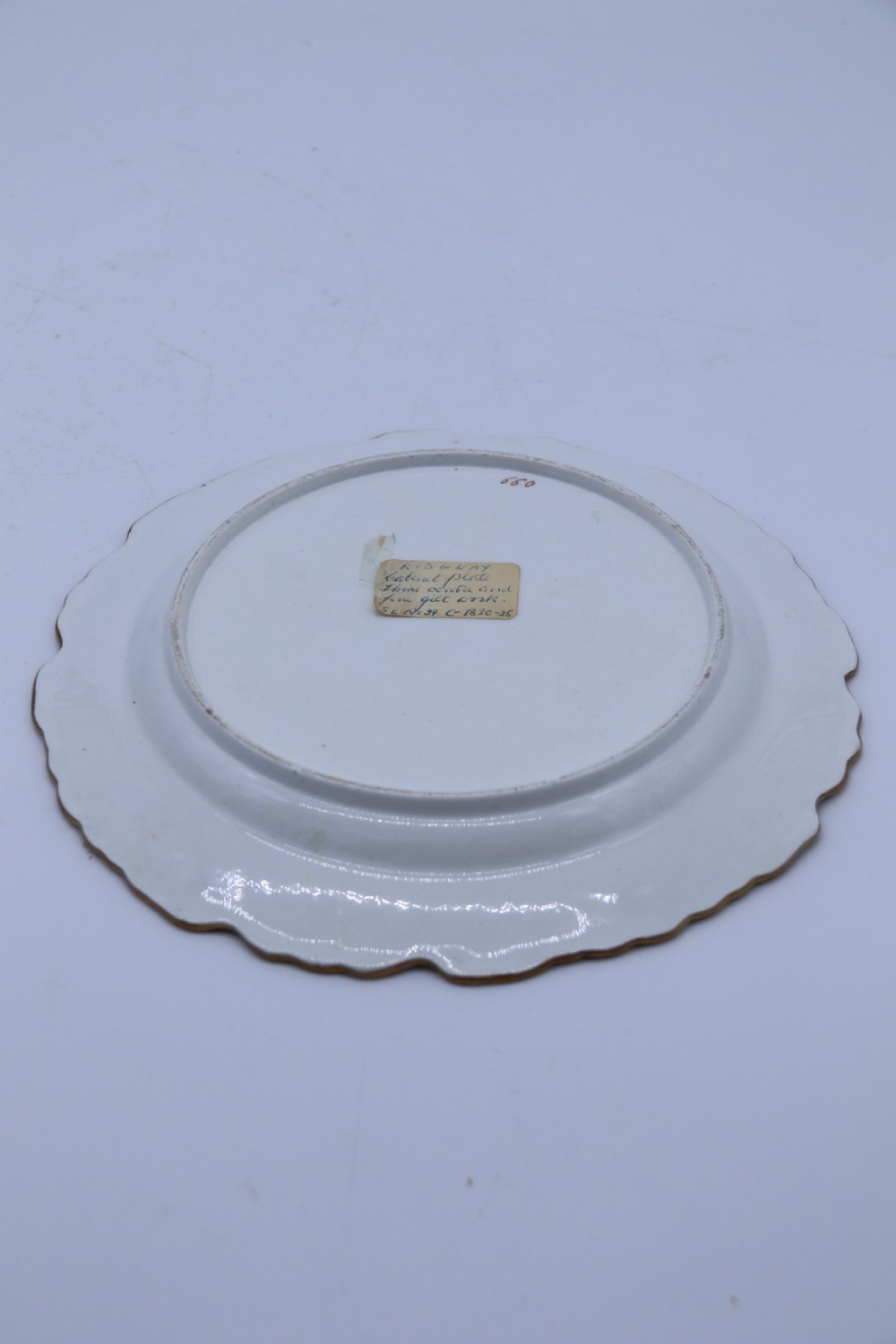 An antique circular English porcelain cabinet plate featuring a cobalt blue and gold scroll border surrounding a central hand-painted floral bouquet. View II