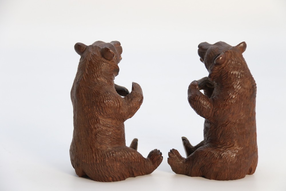 A pair of hand-carved dark brown linden wood Black Forest bears depicted sitting on their haunches with open jaws. View VI