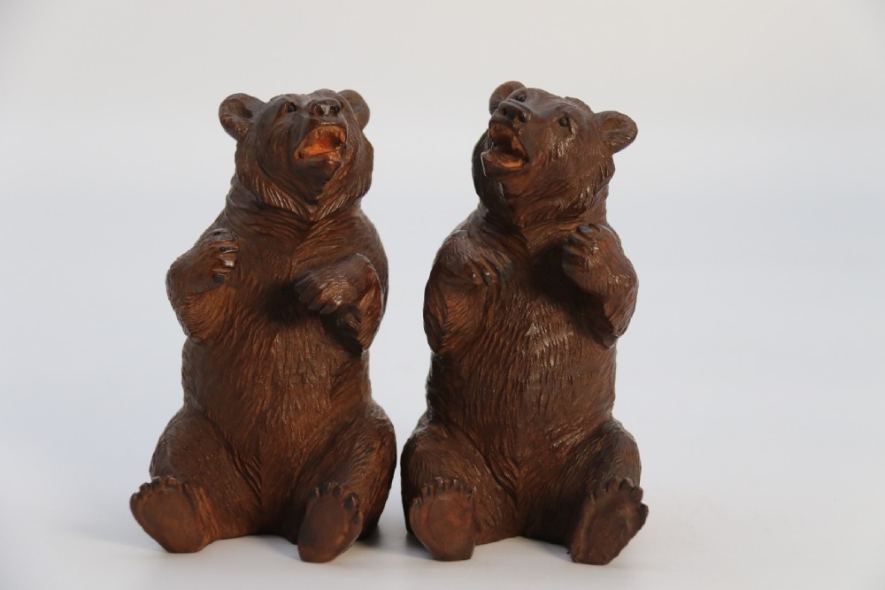 A pair of hand-carved dark brown linden wood Black Forest bears depicted sitting on their haunches with open jaws. View XII