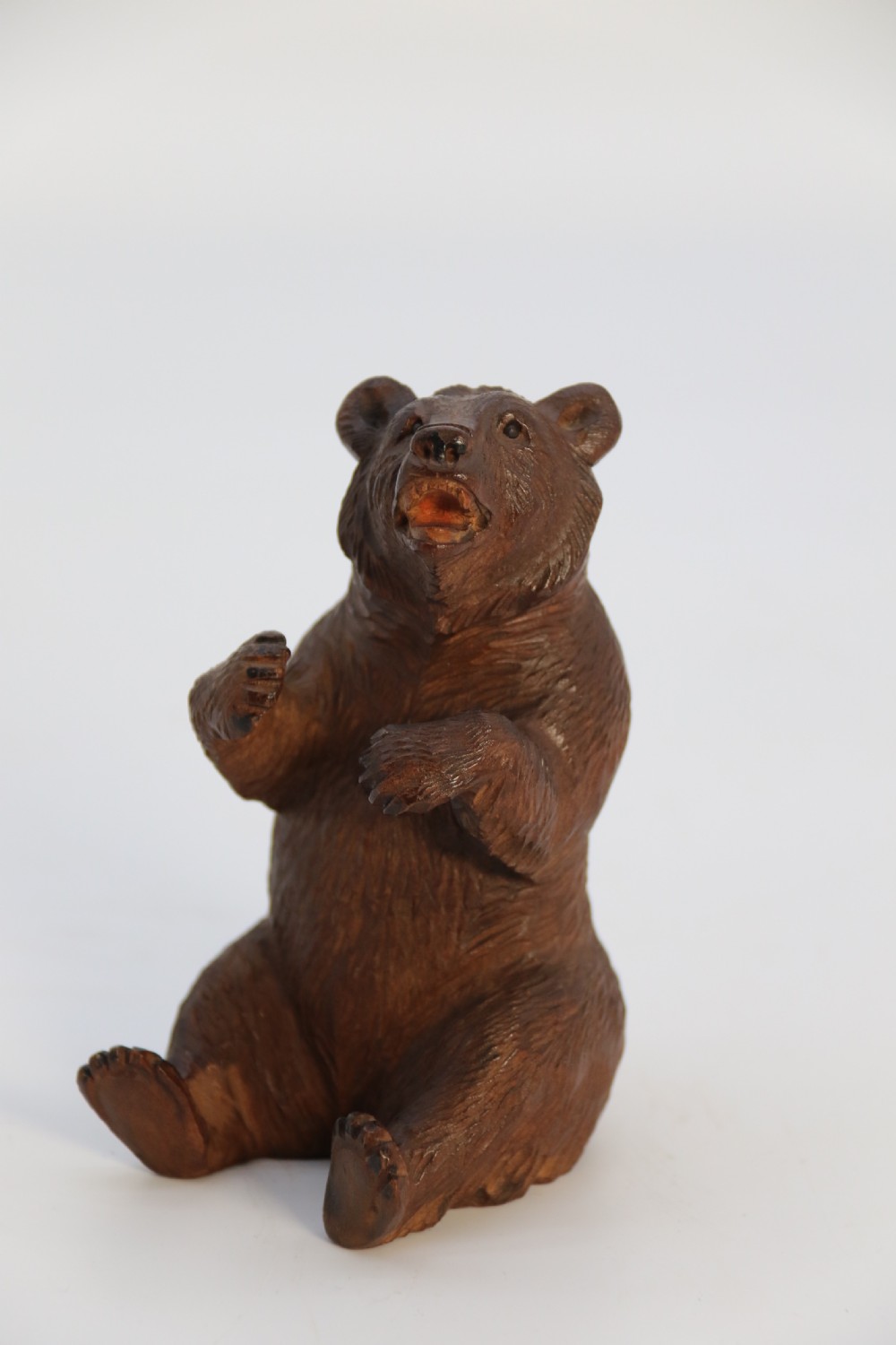 A pair of hand-carved dark brown linden wood Black Forest bears depicted sitting on their haunches with open jaws. View XIV