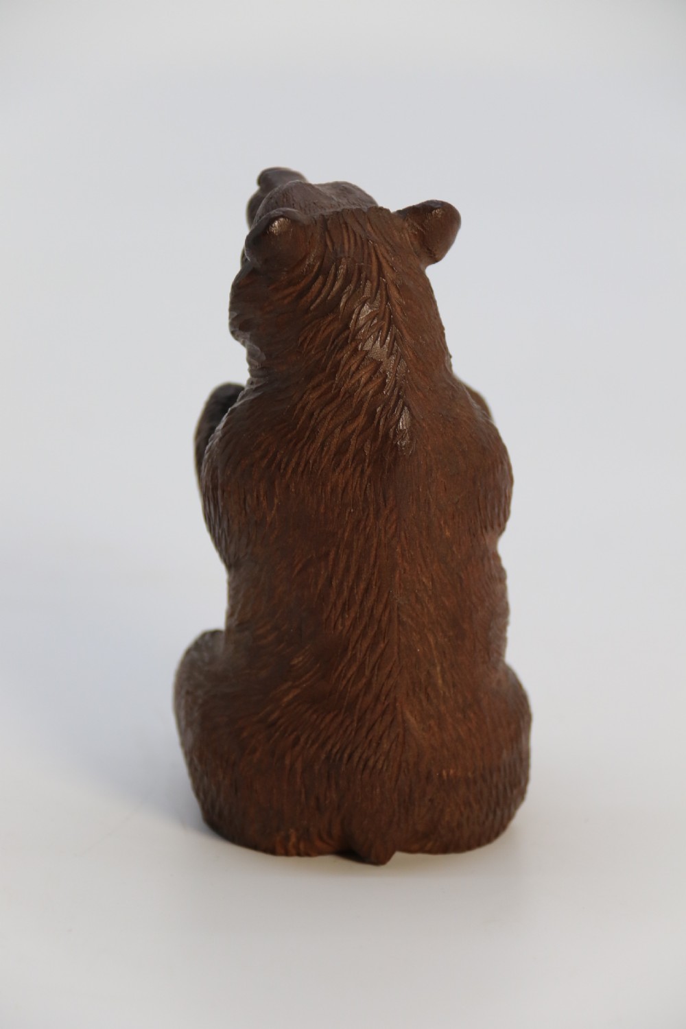 A pair of hand-carved dark brown linden wood Black Forest bears depicted sitting on their haunches with open jaws. View XV