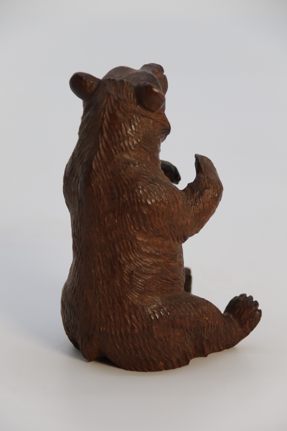 A pair of hand-carved dark brown linden wood Black Forest bears depicted sitting on their haunches with open jaws. View XVI