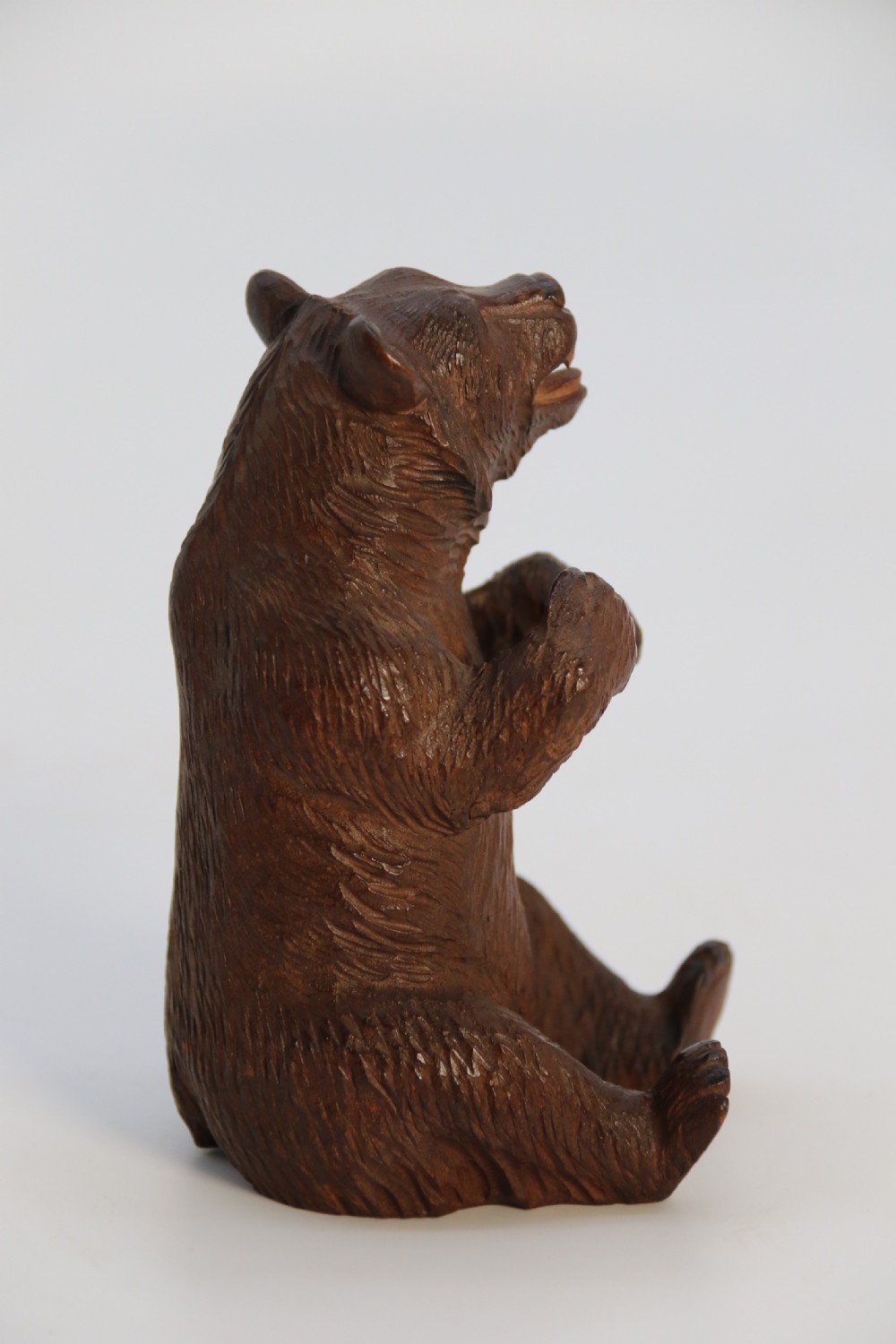 A pair of hand-carved dark brown linden wood Black Forest bears depicted sitting on their haunches with open jaws. View XVIII