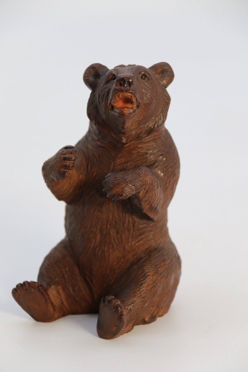 A pair of hand-carved dark brown linden wood Black Forest bears depicted sitting on their haunches with open jaws. View XX