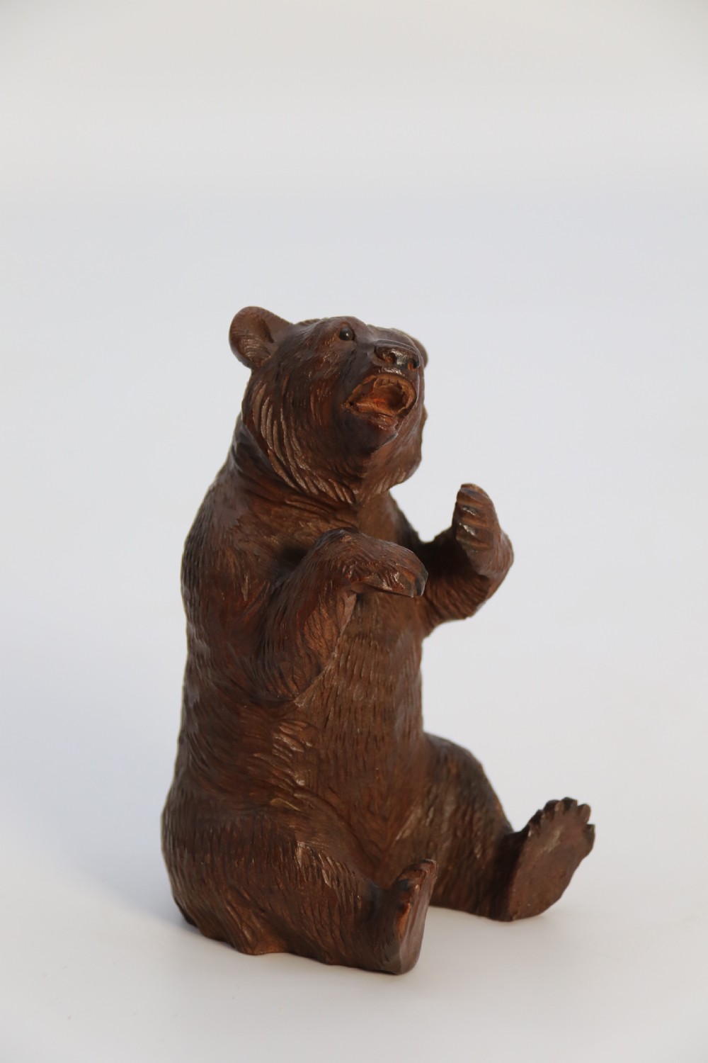 A pair of hand-carved dark brown linden wood Black Forest bears depicted sitting on their haunches with open jaws. View XXI