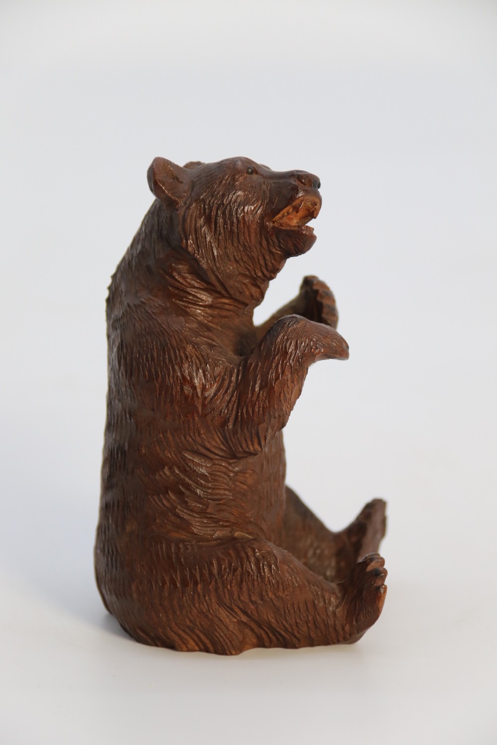 A pair of hand-carved dark brown linden wood Black Forest bears depicted sitting on their haunches with open jaws. View XXII