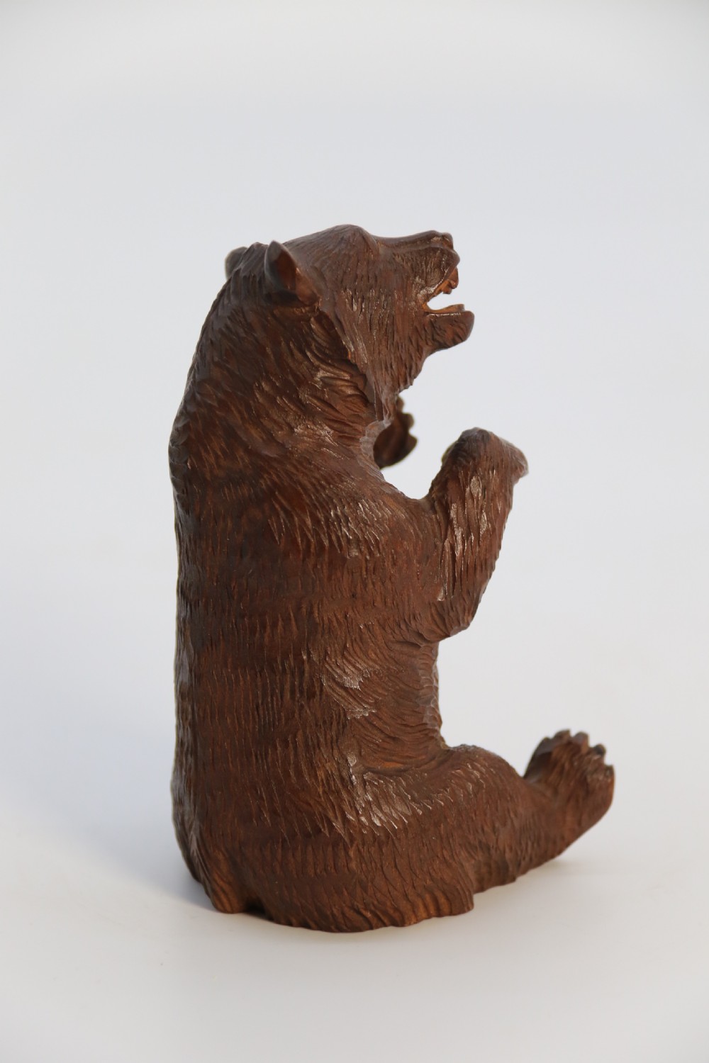 A pair of hand-carved dark brown linden wood Black Forest bears depicted sitting on their haunches with open jaws. View XXIII