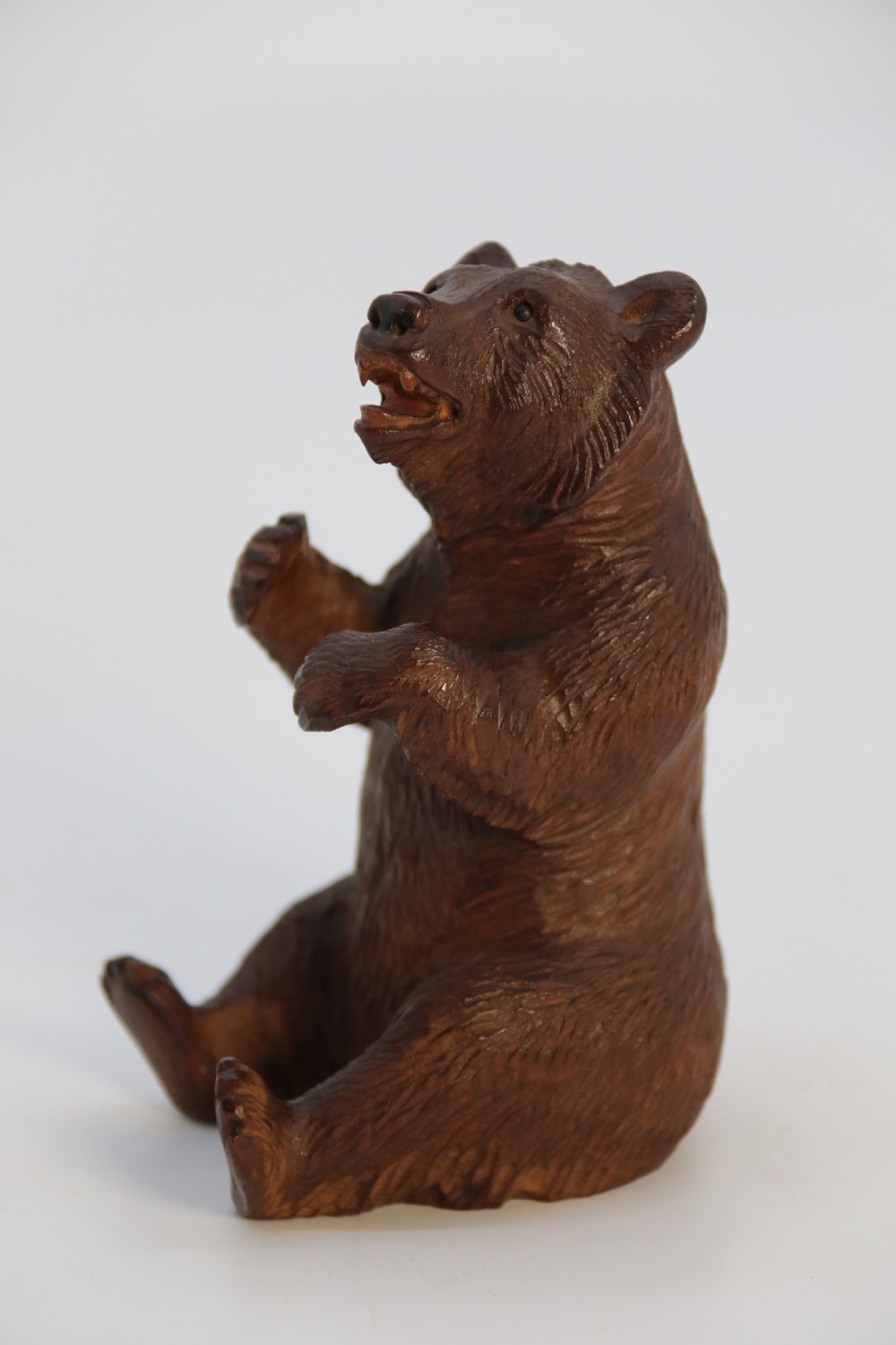 A pair of hand-carved dark brown linden wood Black Forest bears depicted sitting on their haunches with open jaws. View XXV