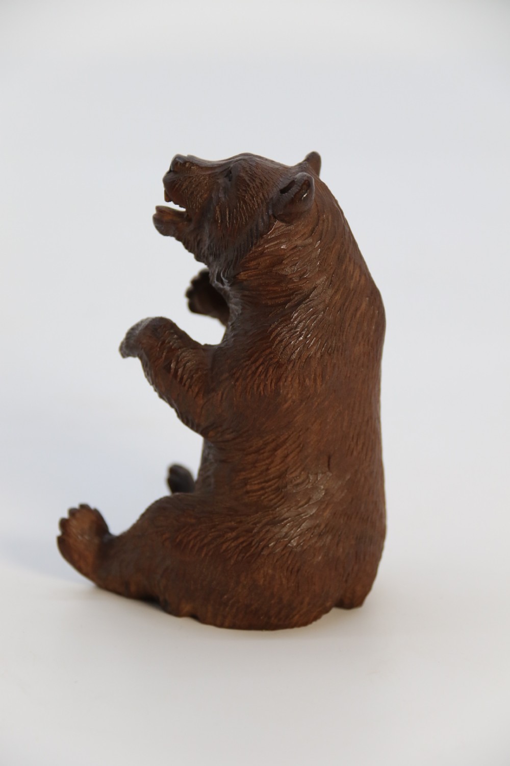 A pair of hand-carved dark brown linden wood Black Forest bears depicted sitting on their haunches with open jaws. View XXVI