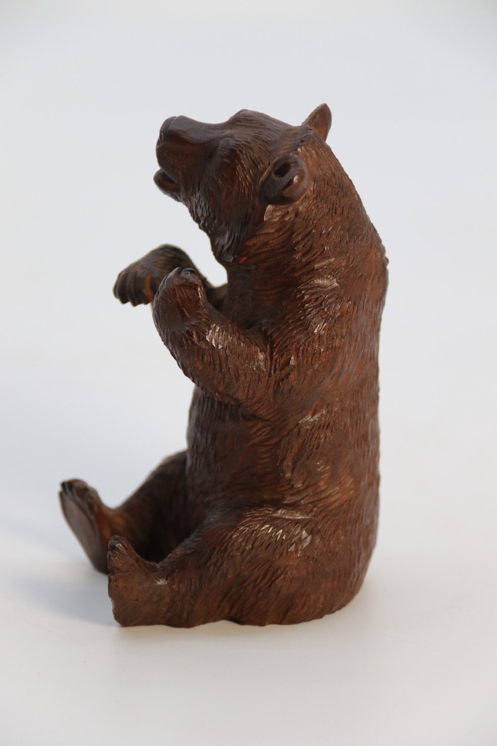 A pair of hand-carved dark brown linden wood Black Forest bears depicted sitting on their haunches with open jaws. View XXVIII