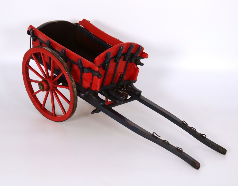 A detailed handmade wooden scale model of an 18th-century farm cart featuring red painted sides, dark blue framing and shafts, and spoked red wheels. View IV