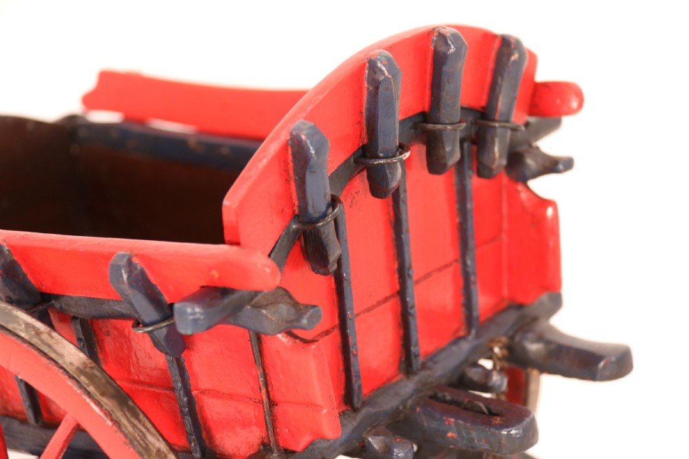 A detailed handmade wooden scale model of an 18th-century farm cart featuring red painted sides, dark blue framing and shafts, and spoked red wheels. View XII