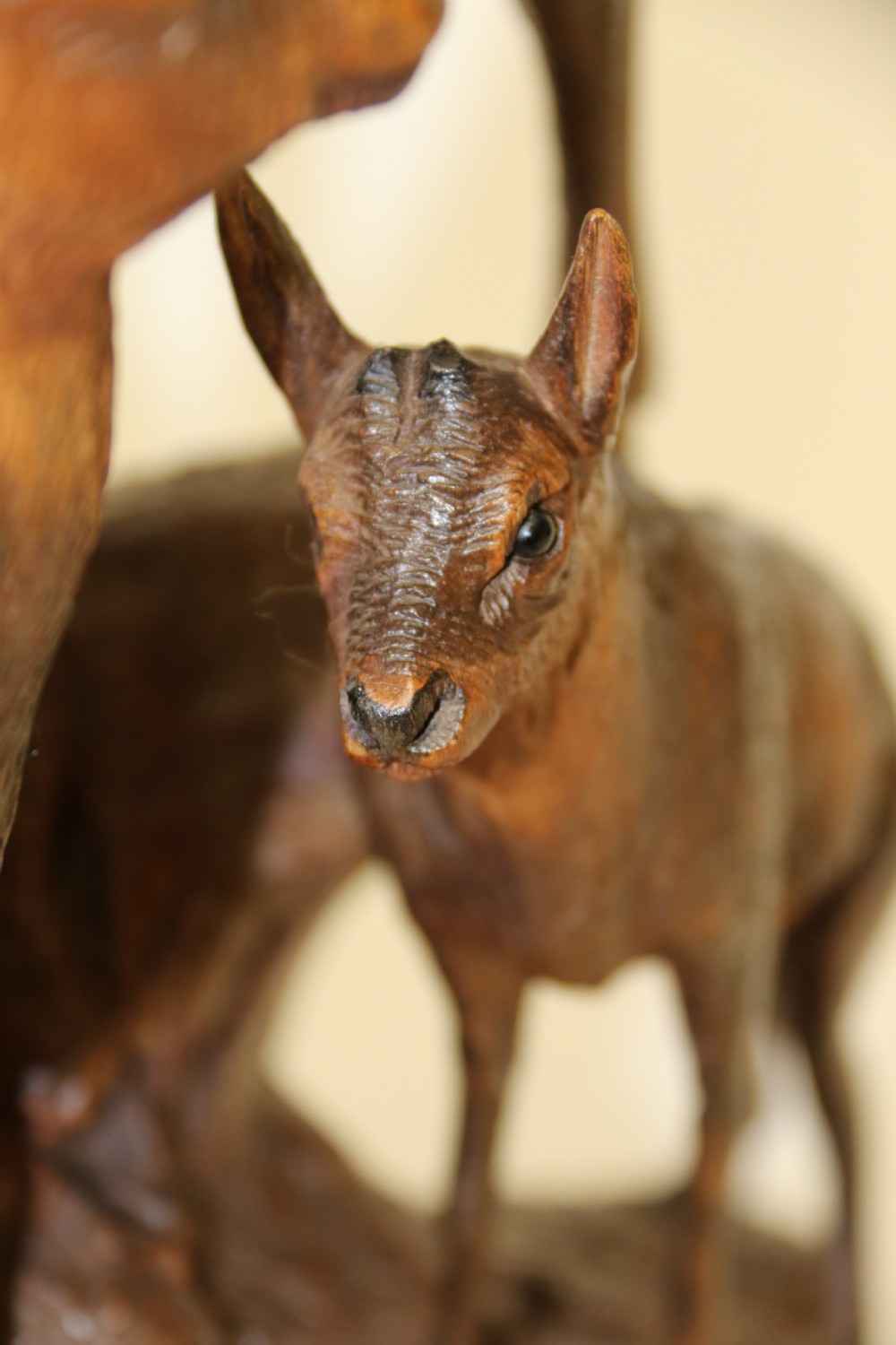 A pair of hand-carved wooden sculptures depicting ibex and chamois with offspring on carved rocky bases. View V