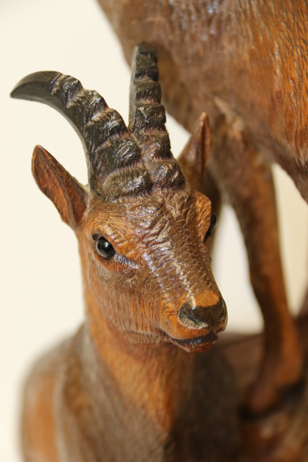 A pair of hand-carved wooden sculptures depicting ibex and chamois with offspring on carved rocky bases. View VI