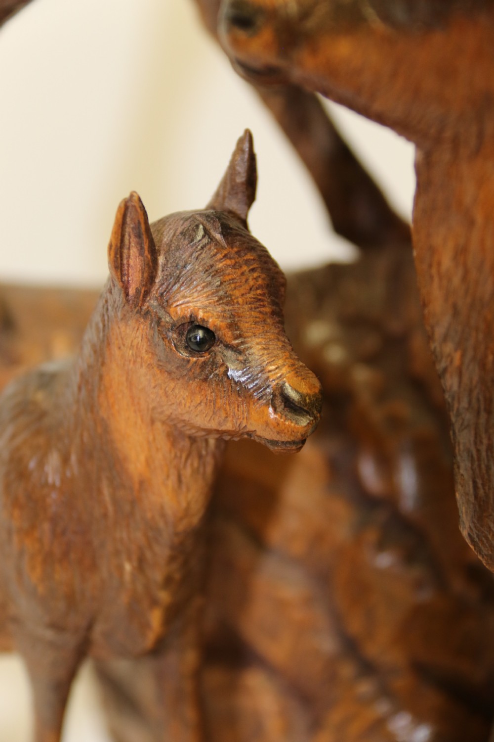 A pair of hand-carved wooden sculptures depicting ibex and chamois with offspring on carved rocky bases. View XI