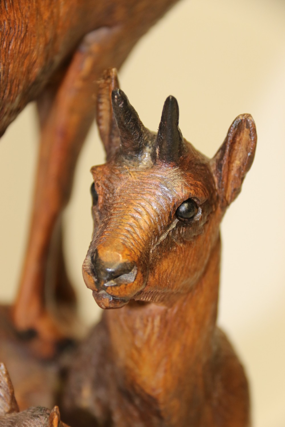 A pair of hand-carved wooden sculptures depicting ibex and chamois with offspring on carved rocky bases. View XII