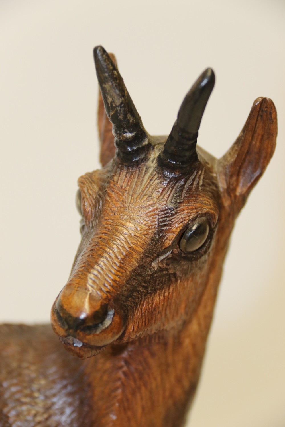 A pair of hand-carved wooden sculptures depicting ibex and chamois with offspring on carved rocky bases. View XV