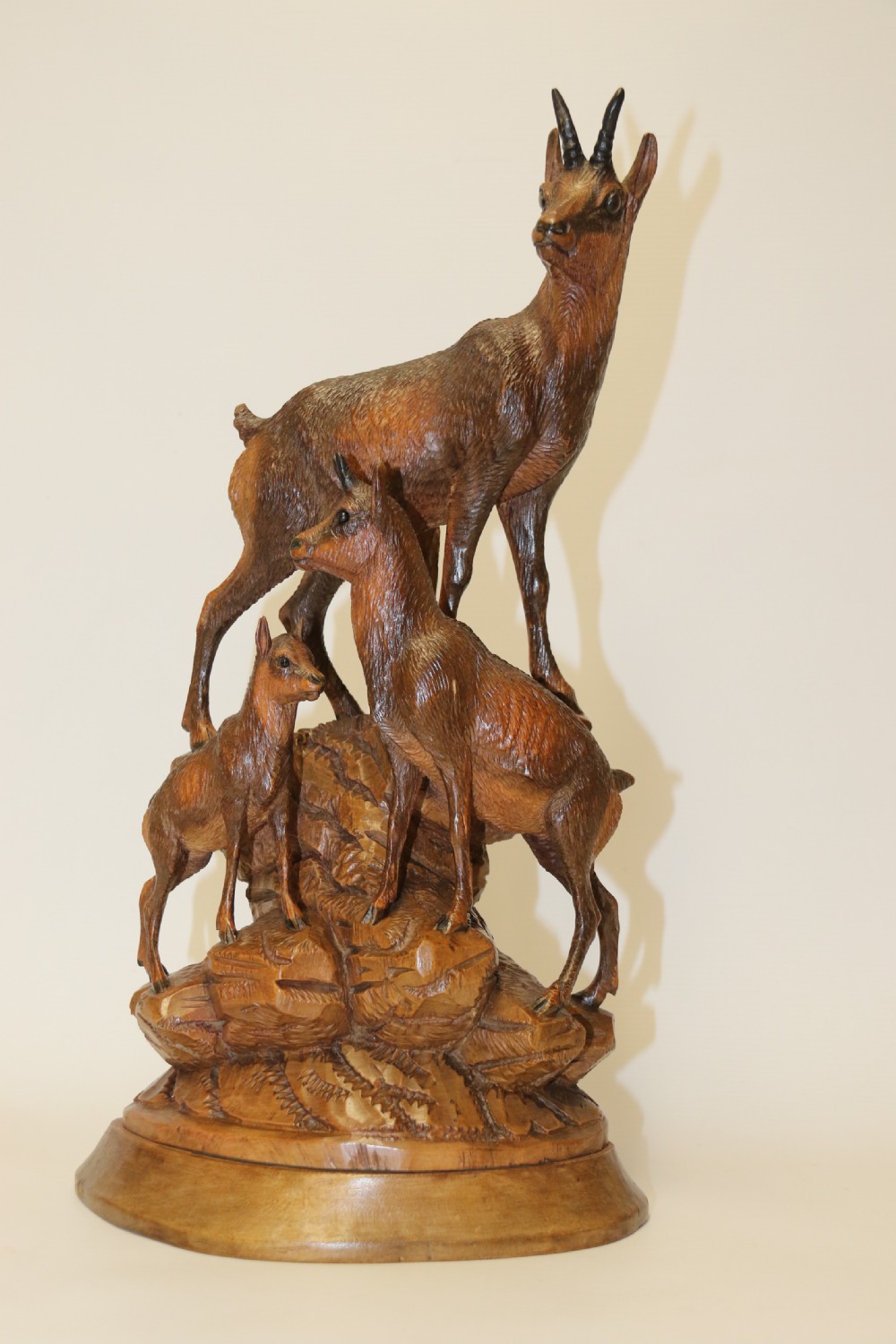 A pair of hand-carved wooden sculptures depicting ibex and chamois with offspring on carved rocky bases. View XVI