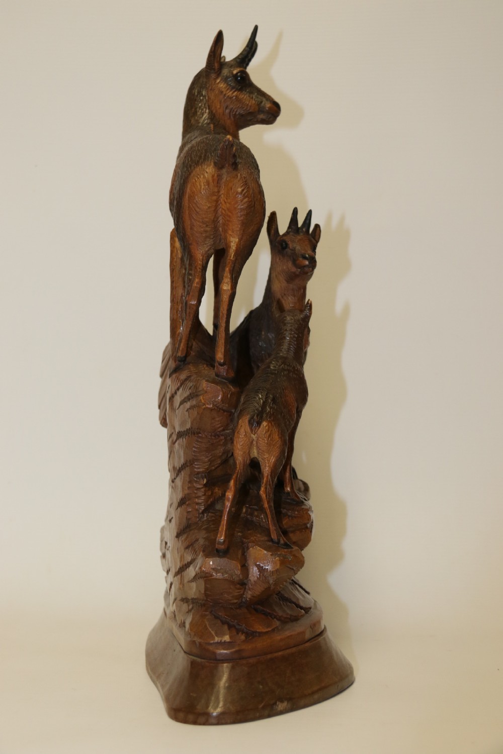 A pair of hand-carved wooden sculptures depicting ibex and chamois with offspring on carved rocky bases. View XVII