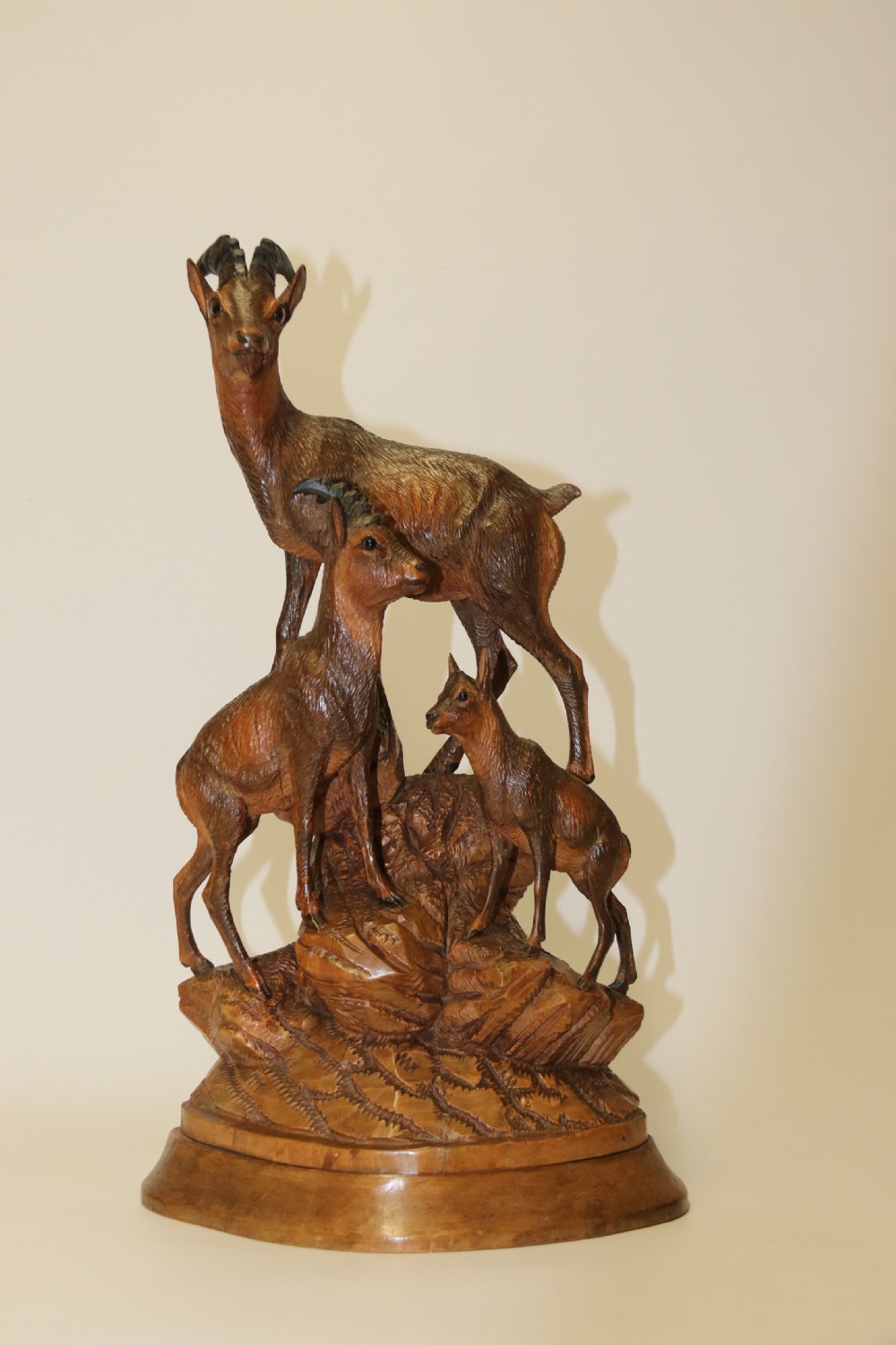 A pair of hand-carved wooden sculptures depicting ibex and chamois with offspring on carved rocky bases. View XVIII