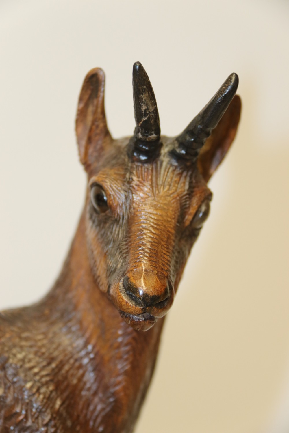 A pair of hand-carved wooden sculptures depicting ibex and chamois with offspring on carved rocky bases. View XX